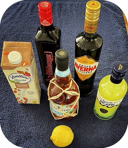 Die Zutaten: Rum, Kirschlik&ouml;r, Limoncello, Bitterlik&ouml;r, Mandelmilch und eine Zitrone